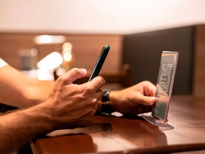 Restoran müşterisinin QR kod standını okutarak dijital menüye erişmesi